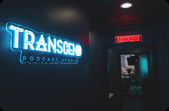 transcend podcast studio neon sign inside the studio